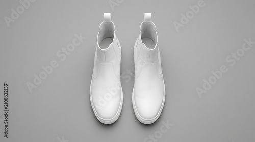 Top Down View of a Pair of White Leather Chelsea Boots with Textured Soles on a Plain Grey Background Studio Shot