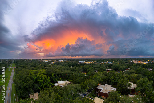 Florida thunderstorm. Dramatic supercell at sunset over Central Florida with towering storm clouds, heavy rain and vivid orange sky. Extreme weather, hurricane season, climate change. Nature Photo.