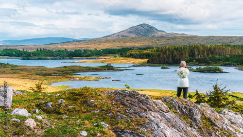 Foto Woman looks at a lake in Connemara National Park, Ireland