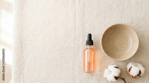 Natural skincare products arranged on neutral tablecloth with cotton  