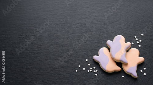Spooky halloween cookies arranged in a minimal flat lay on a black background 