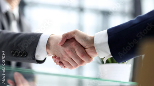 Businessmen shake hands in close-up in the office