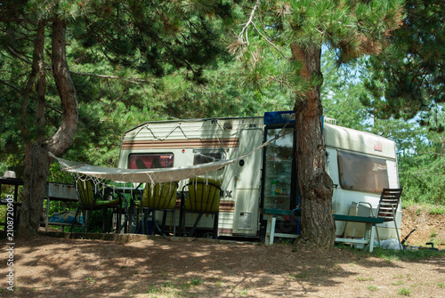 Camper parked on the peaceful shore of a lake, surrounded by tranquil water and scenic natural landscapes.