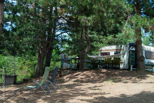 Camper parked on the peaceful shore of a lake, surrounded by tranquil water and scenic natural landscapes.