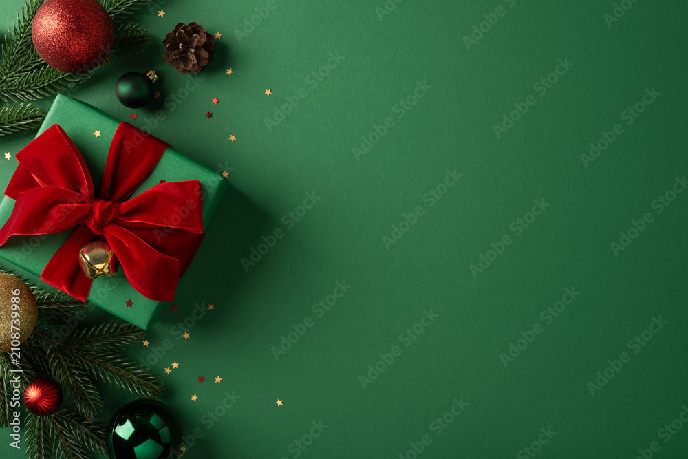 Fototapeta premium Merry Christmas green gift with red bow and ornaments for a happy New Year celebration