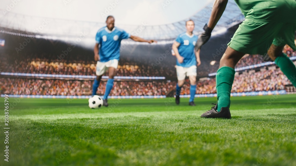 Obraz premium Selective focus captures a striker kicking the ball into the net for a winning goal in front of the goalkeeper, showing dynamic live match action and attacking movement on the pitch.