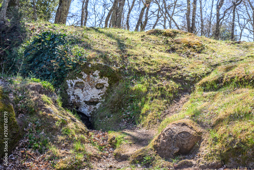 Carved stone faces in the tufa rock along the Via Cava di San Rocco, Sorano, Italy