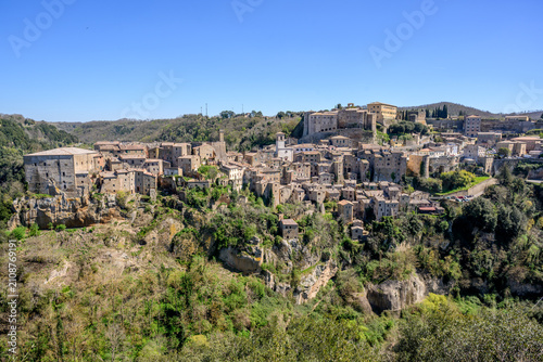 Obraz na płótnie Panorama of Sorano perched on tufa cliffs above a green gorge, Tuscany, Italy