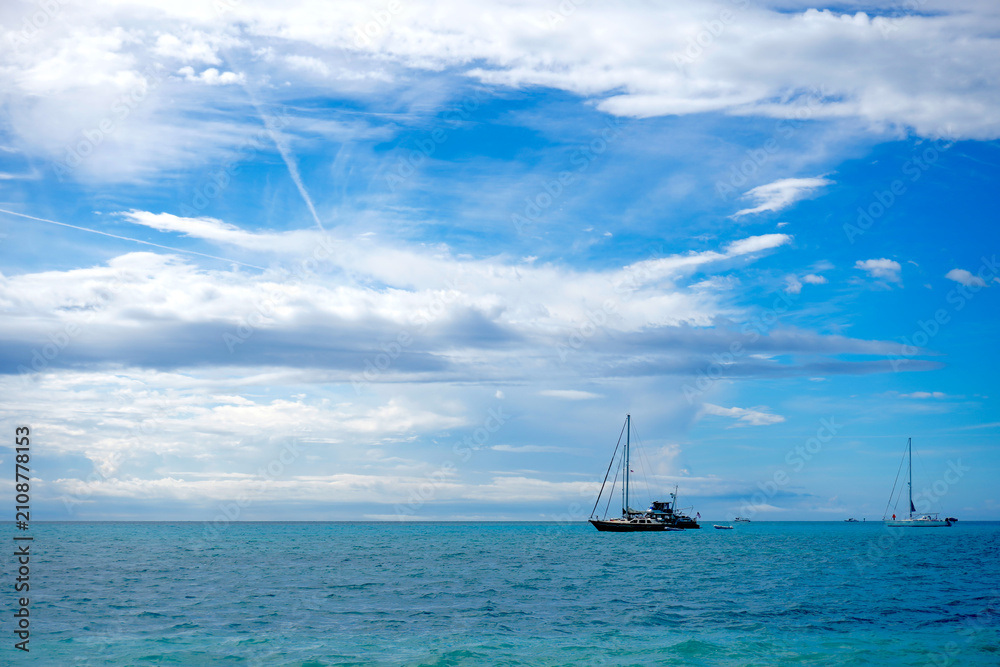 Obraz premium Sailboats Anchored in Open Turquoise Ocean Under Blue Sky