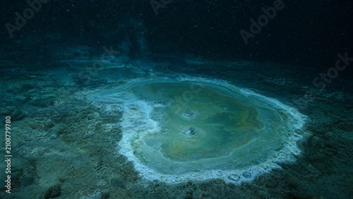 Cold seep with white bacterial mats bordering a shimmering brine pool on the seabed