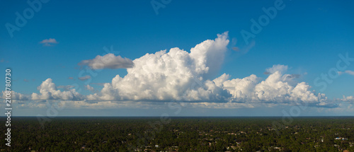 Cuadro en lienzo Blue sky with flying white clouds over Florida suburbs
