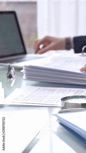 Business colleagues accountants or auditors reviewing financial data in office. Two professionals analyzing paper reports and using calculators. Audit and taxes