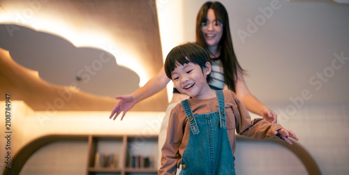 Happy boy playing with mom, a parent helping her child at home