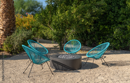 Outdoor chairs and fire pit in desert landscape yard during the day
