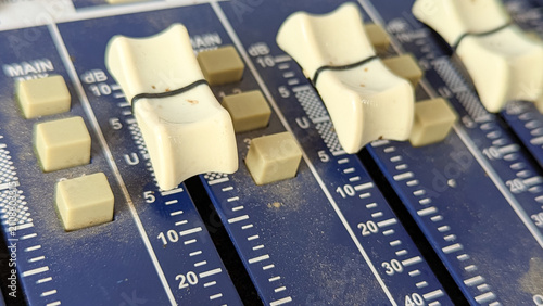 Schilderij op canvas Macro shot of white fader sliders on an analog audio mixing console board with decibel level markings