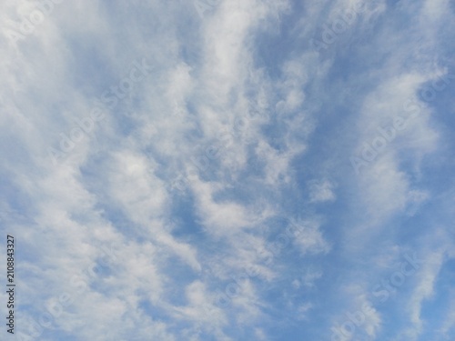 Obraz na plátně Clear bright blue sky covered with soft wispy white clouds in natural pattern