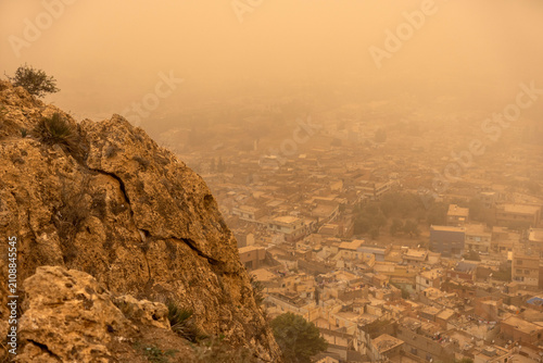City of Tlemcen Dissolving Into Thick Orange Dust Storm Haze from Rocky Hillside Overlook