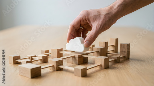 Hand placing last wooden block on top of stacked blocks in warm light