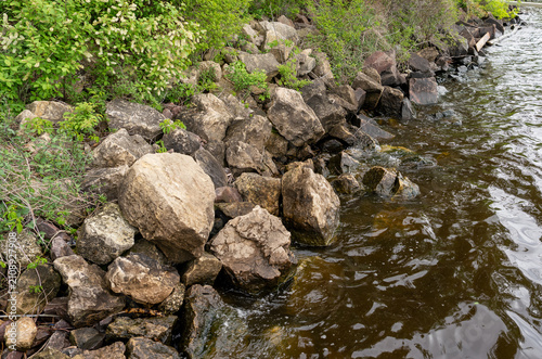 Canvas Print Rocky shoreline erosion control barrier on a lake