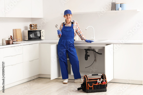 Smiling female plumber in b...