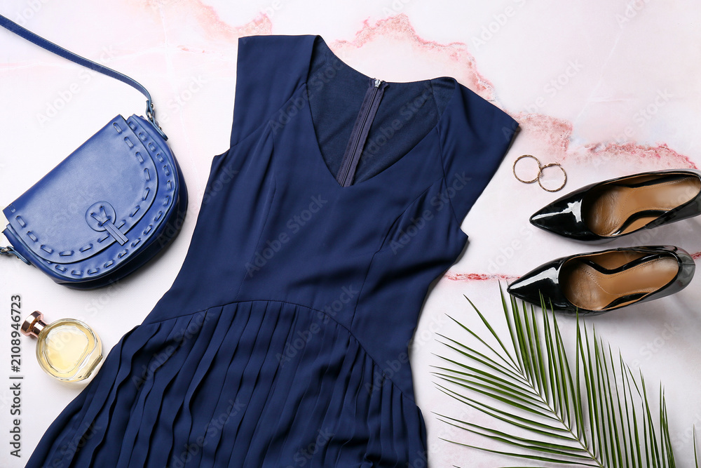 Obraz premium Composition with stylish female dress, shoes, accessories and palm leaf on light background