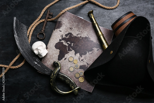 Tableau sur toile Pirate hat with map, skull, sword and rope on dark background