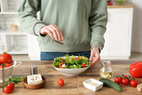 Young woman salting fresh v...