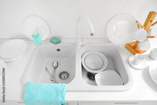 Clean dishes in white sink ...