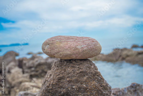 Stone on the beach with blue sky and sea background, stock photo