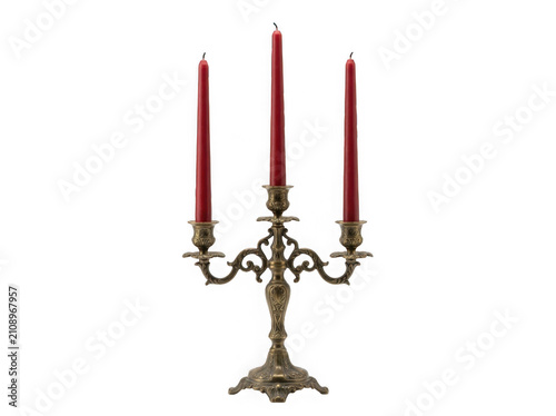 An ornate antique brass candelabra with three tall red candles isolated on transparent background