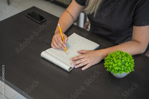 Foto Asian woman drawing a picture on sketch book