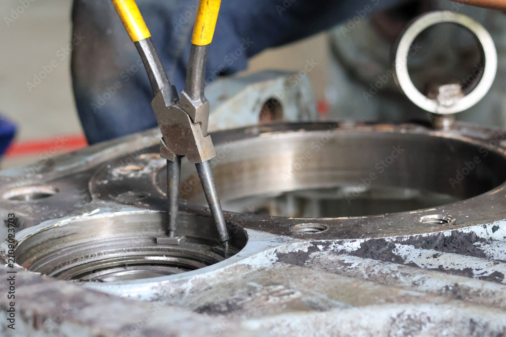 Fototapeta premium Mechanic Using Retaining Ring Pliers on Machinery.