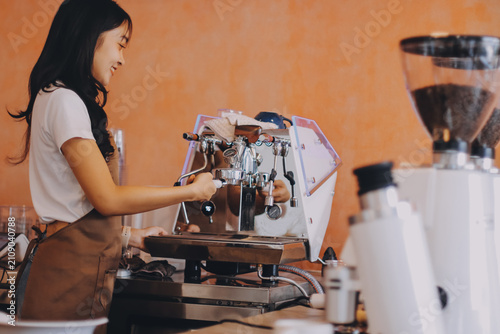 Young woman at barista school learning how to make espresso coffee.