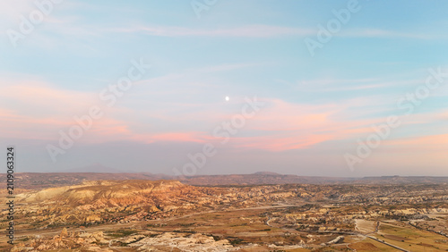 Schilderij op canvas Aerial View of Cappadocia's Fairy Chimneys Under a Twilight Sky with a Visible M
