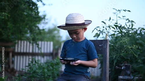 4 Year Old ASEAN Boy Using Tablet in Vegetable Garden Exploring Smart Farming AI Technology and Future Food Security Concept
