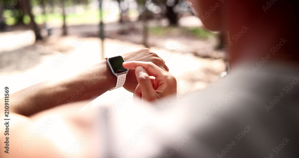 Fototapeta premium Fitness, man and hands with watch for heart rate, calories or monitoring performance in nature. Active, male person or checking health with wristwatch for step counter, workout app or exercise goals