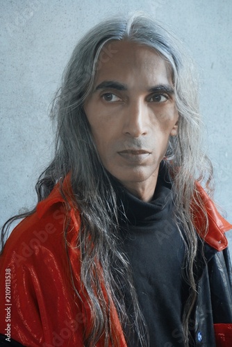 A striking three-quarter close-up portrait capturing a dynamic head turn with an off-camera gaze directed toward the upper left frame. The body is angled slightly toward the light.