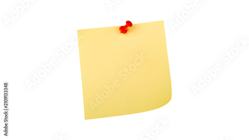 Curled yellow sticky note pad sheet with a red plastic push pin isolated on white background