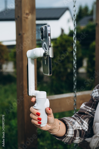 Close-up of hand holding smartphone on gimbal stabilizer for mobile video recording