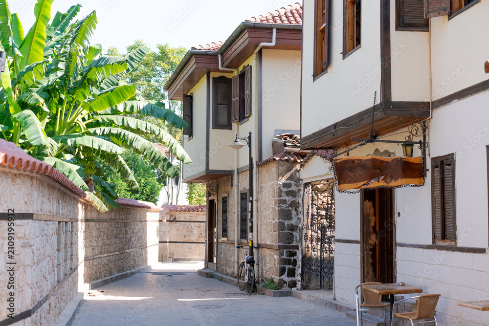 Fototapeta premium Kaleici Cobble Alley with Ottoman Houses and Banana Plants at Antalya