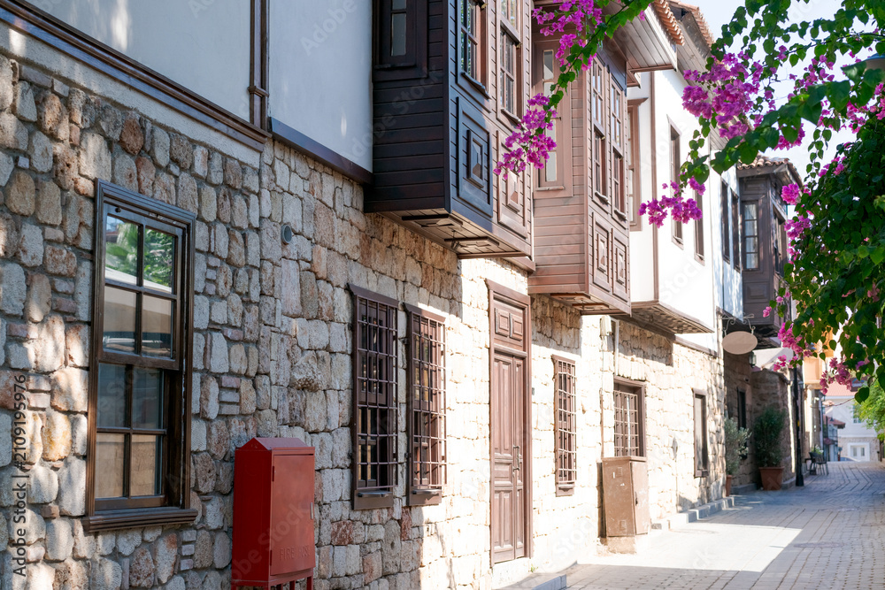 Fototapeta premium Kaleici Alley with Ottoman Houses and Pink Bougainvillea at Antalya