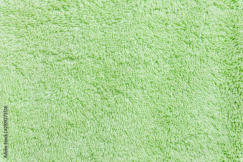 Fresh pastel green cotton textile texture background with space for text. Light green terry towel fabric texture background with copy space.