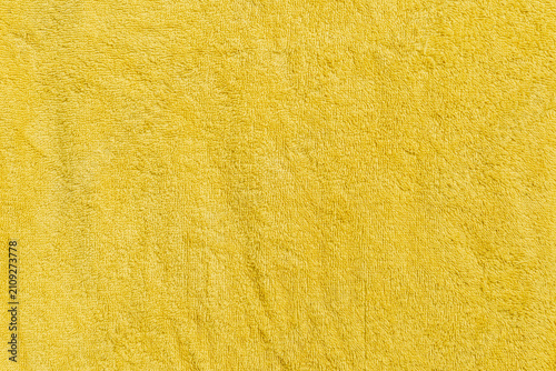 Yellow terry towel fabric texture background with copy space. Minimalist soft cotton towel surface banner featuring loop piles.
