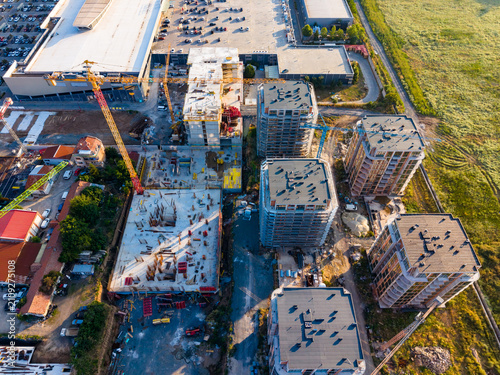 Fotografie Construction site shows multiple buildings being developed near a parking lot wi