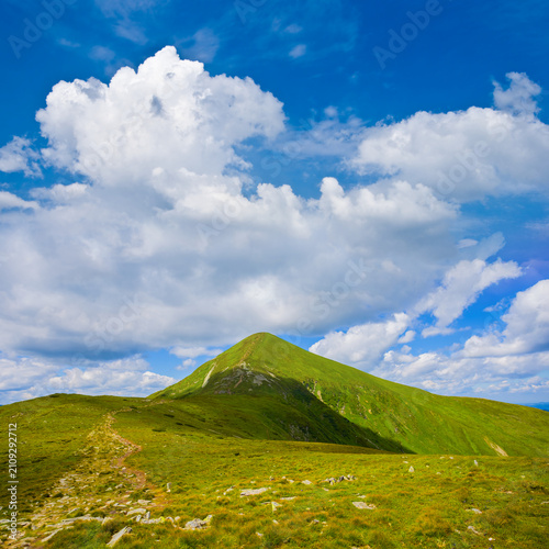 green mountain valley under a blue cloudy sky, summer mountain travel scene