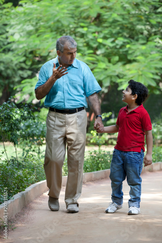 Grandfather and grandson taking a walk in a park