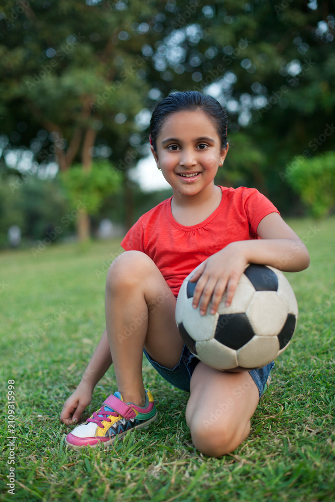 Obraz premium Portrait of a young girl holding a football