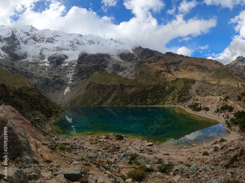 Turquoise Humantay glacial lake under cloudy mountain peaks