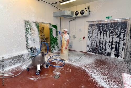 Worker disinfecting interior of a butchery