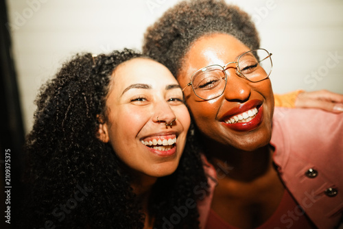 African american girls having fun in the streets after party concert - People lifestyle and nightlife concept - Main focus on afro woman mouth - UGC flash content